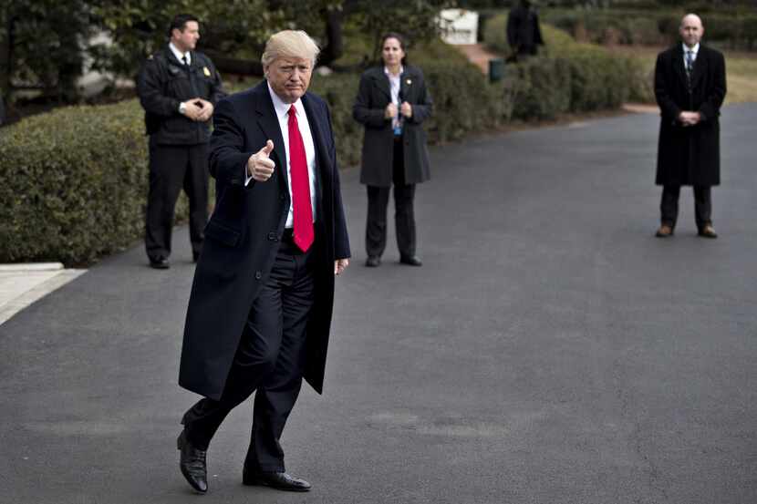 U.S. President Donald Trump gestures toward members of the media as he walks out of the...