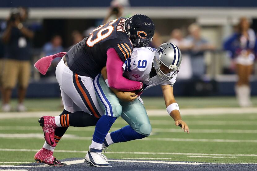 Henry Melton #69 of the Chicago Bears sacks quarterback Tony Romo #9 of the Dallas Cowboys...