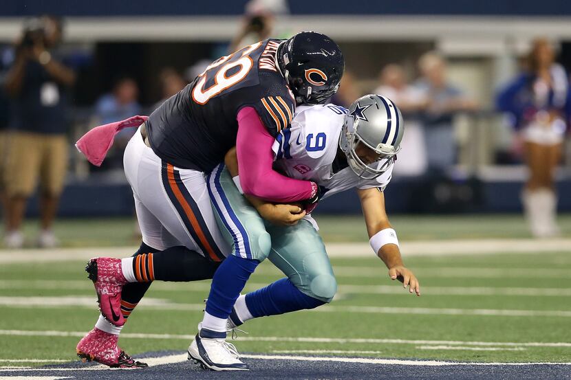 Henry Melton #69 of the Chicago Bears sacks quarterback Tony Romo #9 of the Dallas Cowboys...