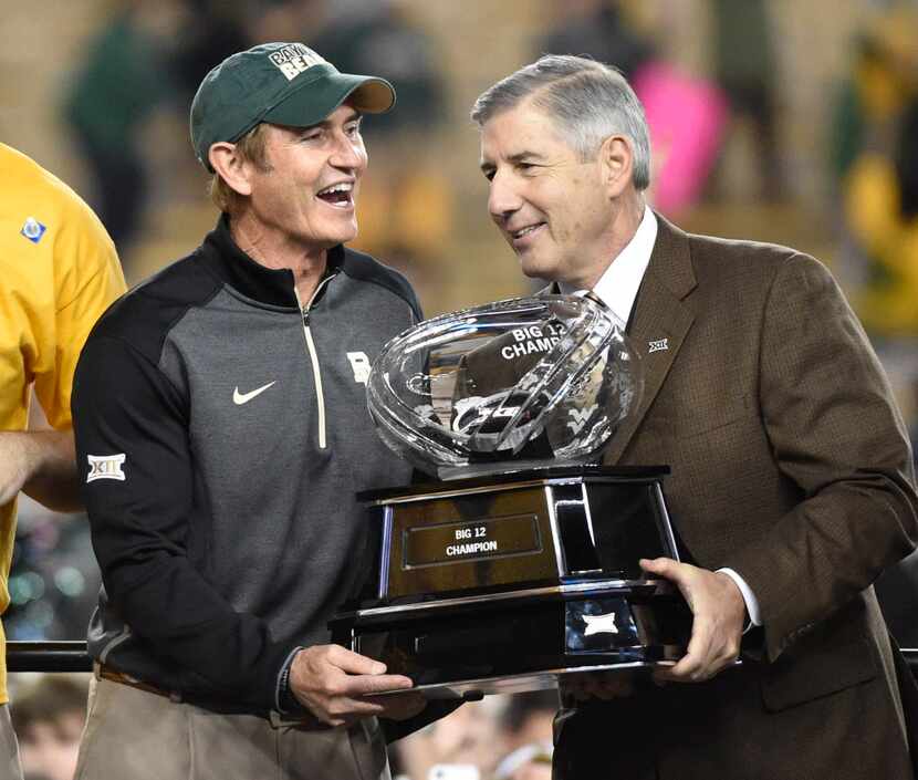 Baylor Bears head coach Art Briles accepts the Big 12 trophy from Big 12 commissioner Bob...