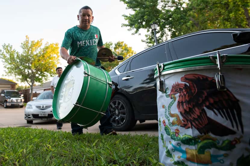 Ariel Lopez, 40, carries a bass drum as he arrives to a friend's home on Friday night, May...