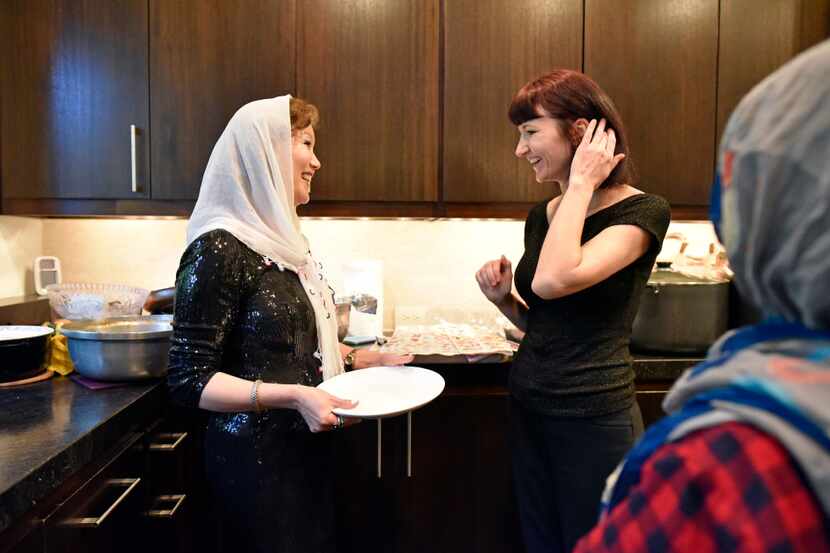 Jamileh Jafari, left, speaks with Olga Pope after preparing an Afghan style dinner for the...