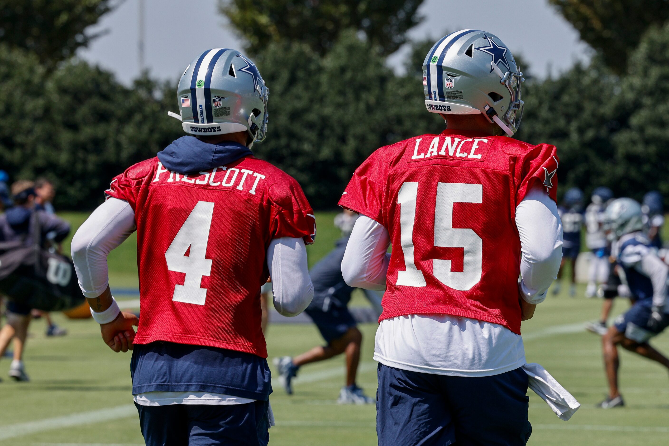 Dallas Cowboys quarterbacks Dak Prescott (4) and Trey Lance (15) jog to the field for a...