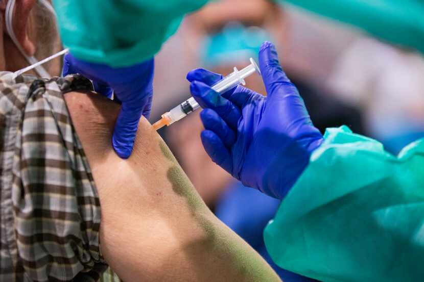 A man is injected with the COVID-19 vaccine at Fair Park in Dallas on Wednesday, Feb. 2, 2021.