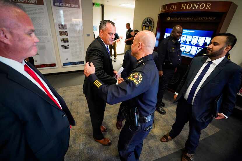 Dallas Police Chief Eddie Garcia (center) shakes hands with Special Agent in Charge Matthew...