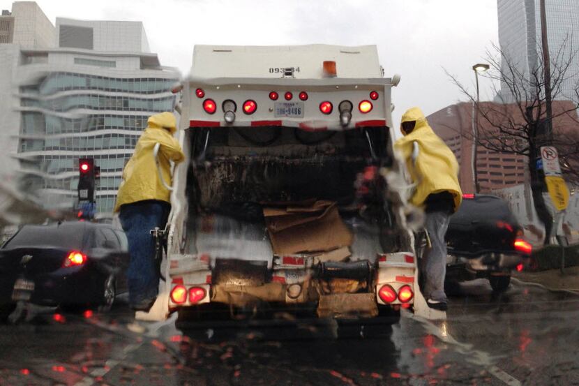 Dallas sanitation employees work through a rainy, windy cold front.