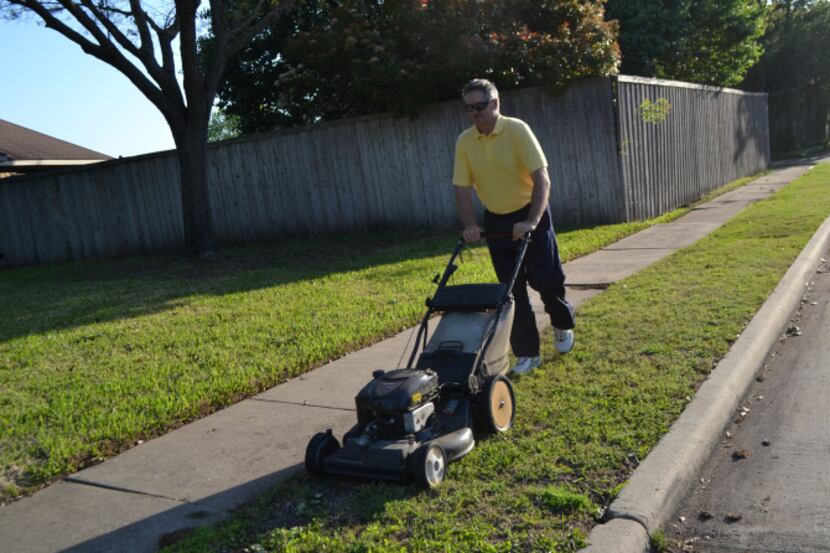 Mark West mows the lawn at his home in Springfield, a subdivision in west Rowlett.