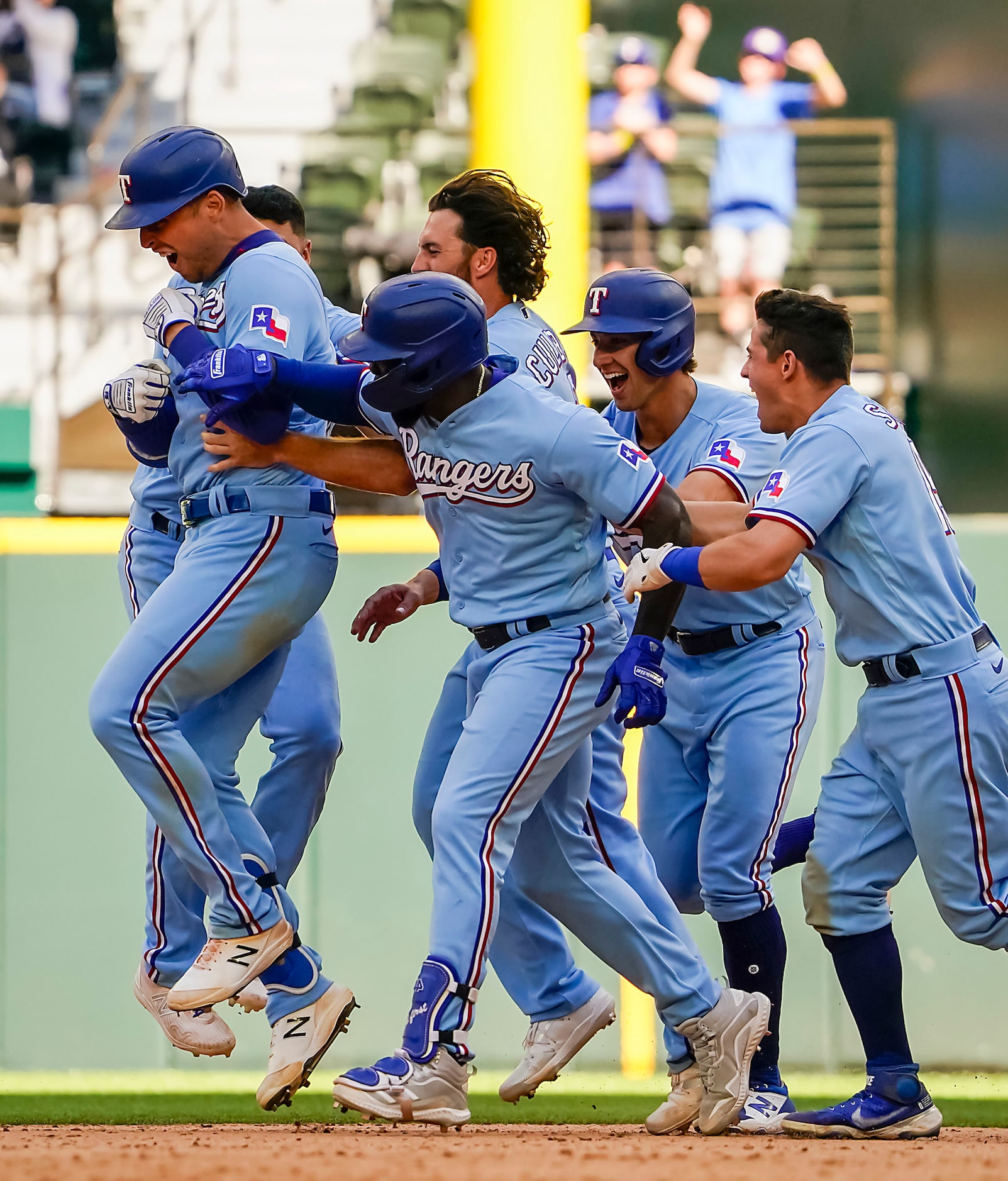 Texas Rangers first baseman Nate Lowe is mobbed by teammates after hitting a walk-off single...