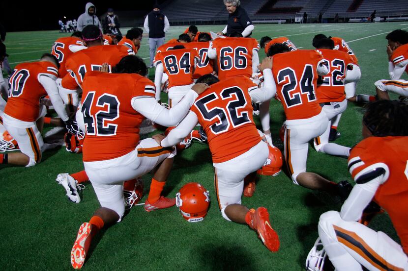 Following a talk by head coach Bobby Estes, North Dallas players pause for a prayer...
