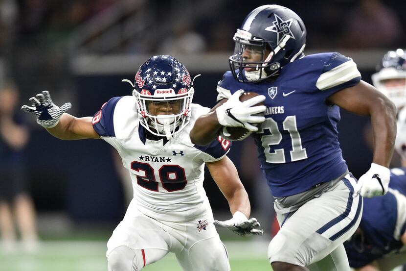 Frisco Lone Star senior running back Kirby Bennett (21) rushes the ball, while being...