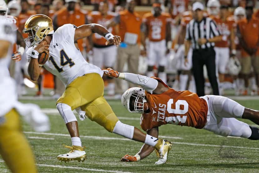 Notre Dame quarterback DeShone Kizer (14) motors past Texas linebacker Malik Jefferson (46)...