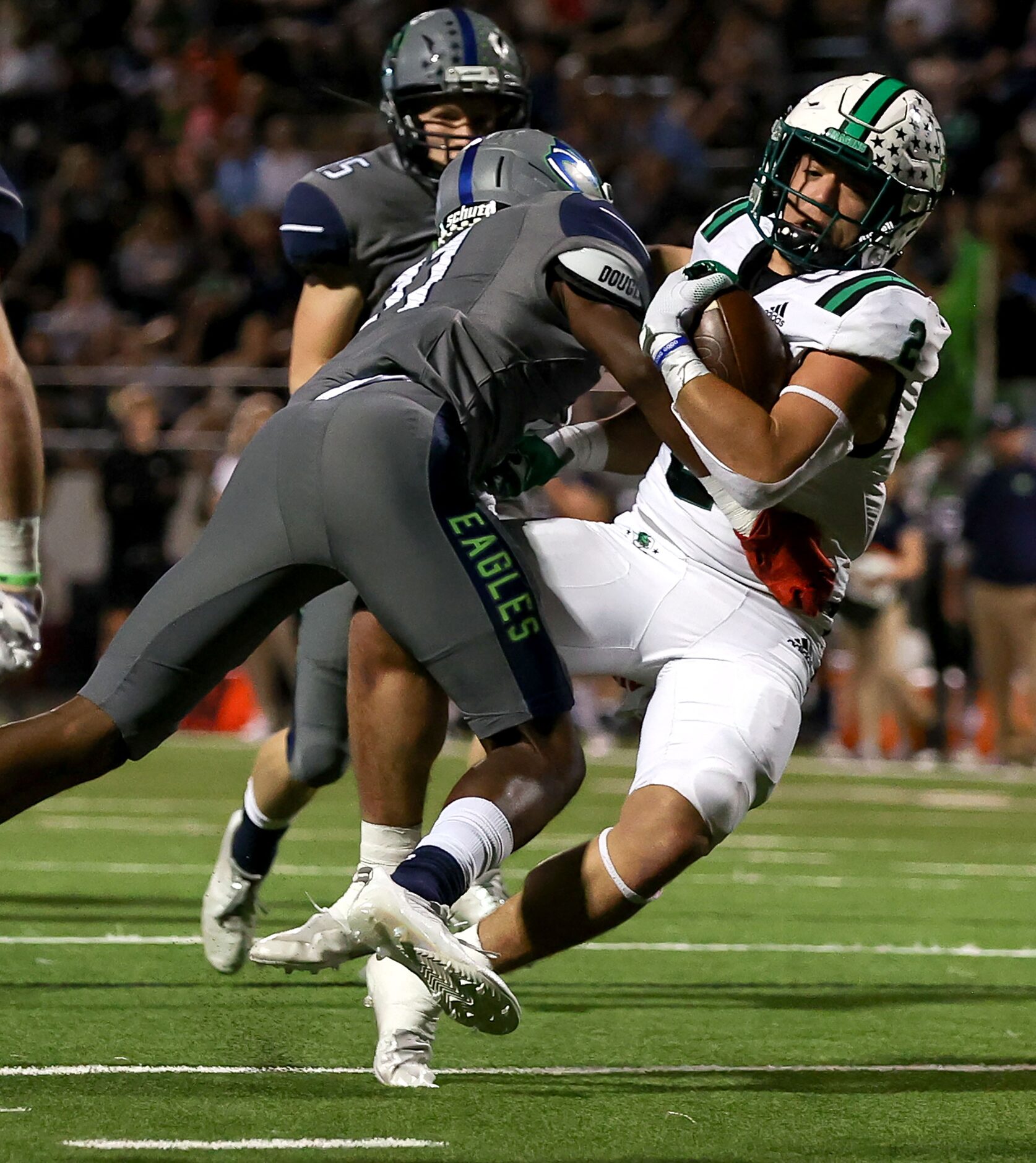 Southlake Carroll running back Owen Allen (2) gets hit hard by Eaton cornerback Chase...