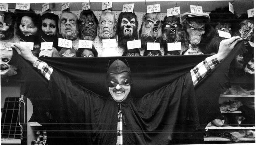 A staffer at Magicland Costume Shop on Forest Lane displays one of the Batman capes.