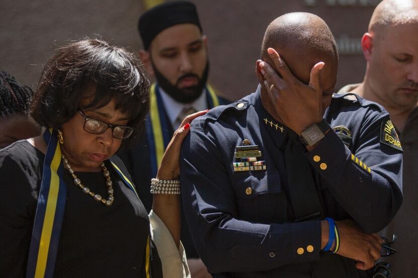 TOPSHOT - Dallas Police Chief David Brown prays during a a vigil at Thanks-Giving square in...