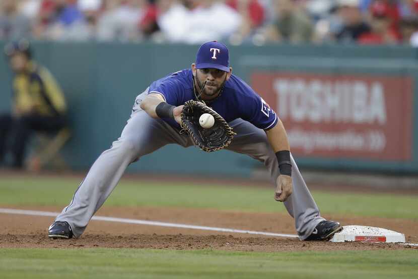Texas Rangers first baseman Mitch Moreland fields the throw during the first inning of a...
