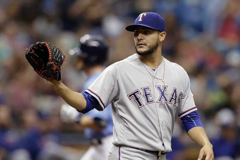 Texas Rangers starting pitcher Martin Perez waits for a new ball as Tampa Bay Rays' Logan...