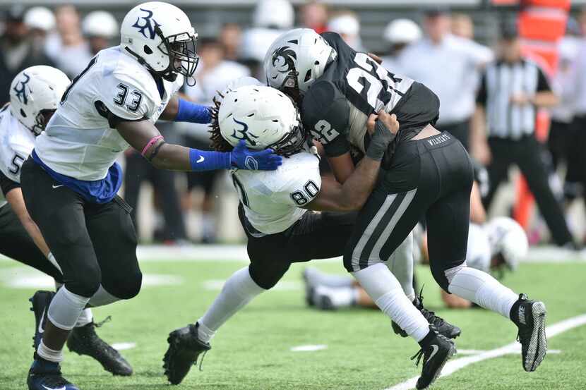 Guyer freshman running back Noah Cain (22) is wrapped up by Byron Nelson senior defensive...