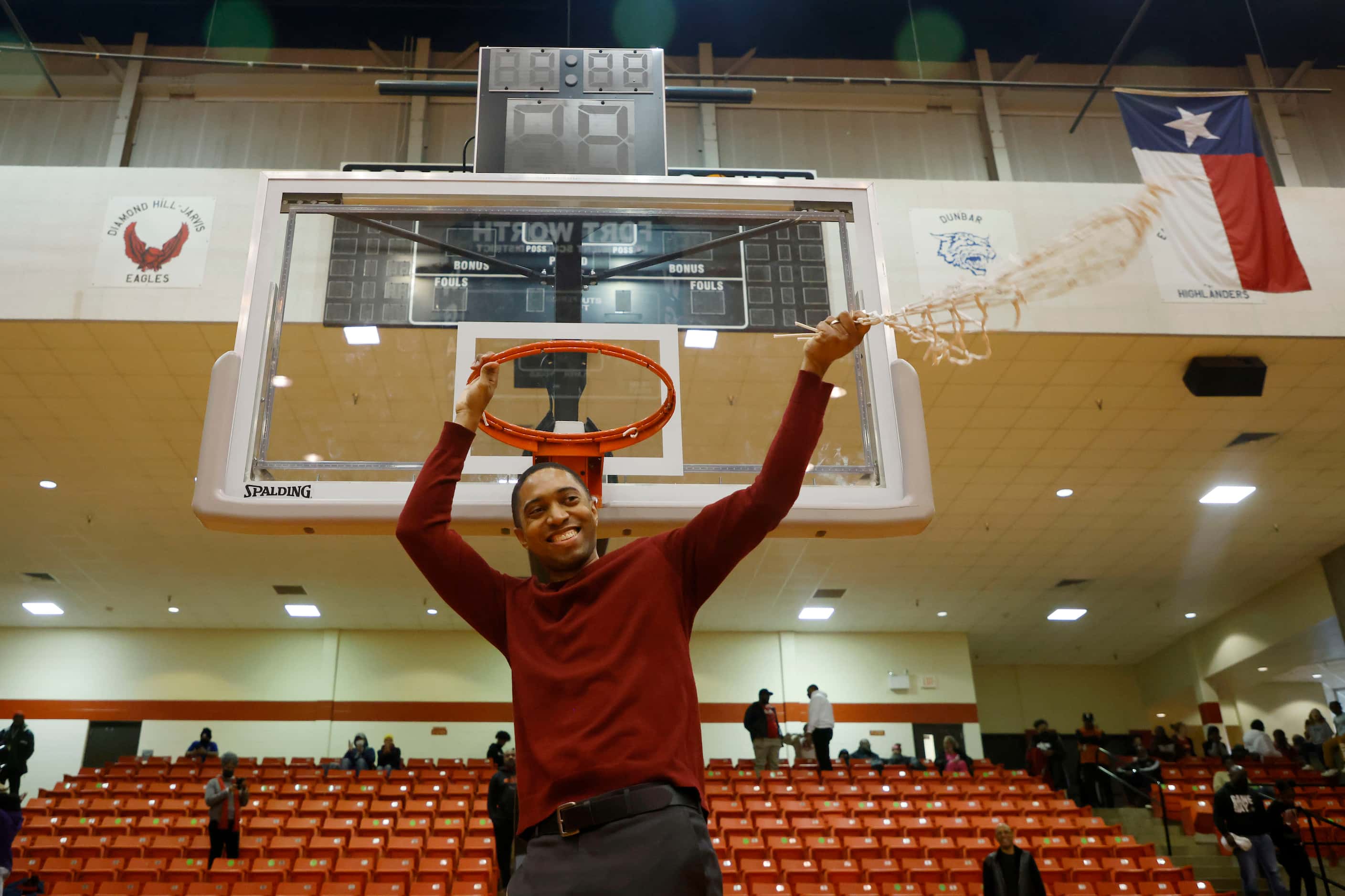 South Grand Prairie head coach Brion Raven waves the net after cutting it off the basket...