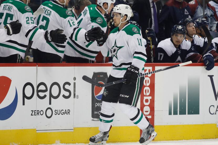 Dallas Stars left wing Curtis McKenzie, front, is congratulated as he passes the team box...