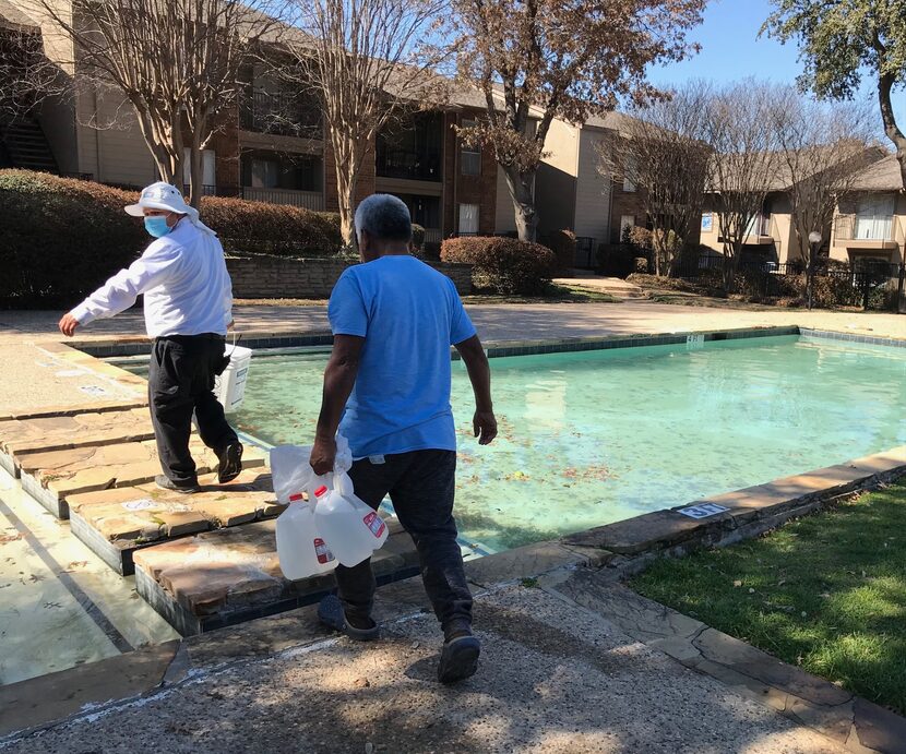 Guillermo Granado carries water from hoses near the swimming pool of a Vickery Meadow...