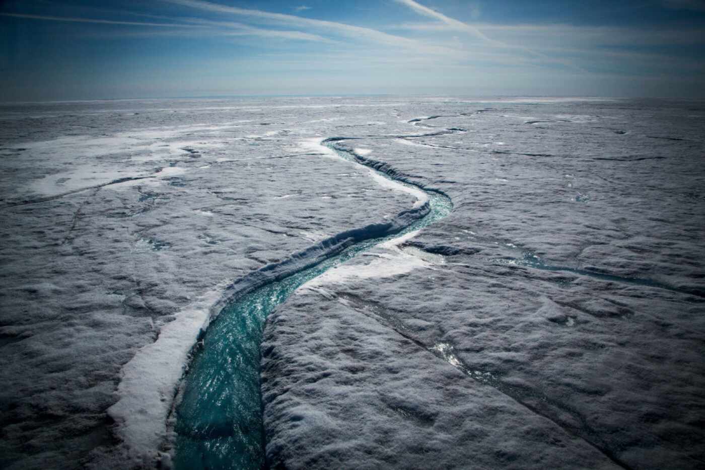  Meltwater flows along a supraglacial river on the Greenland ice sheet, one of the biggest...