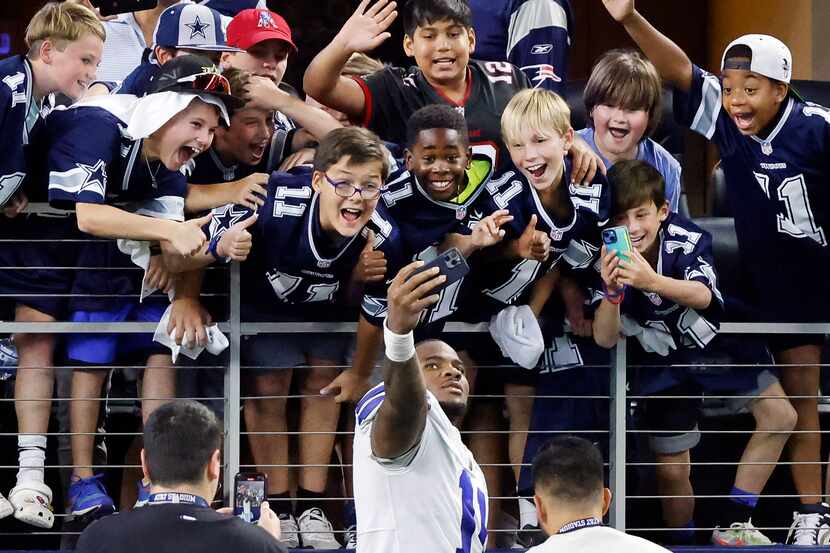 After the game, Dallas Cowboys linebacker Micah Parsons (11) took a selfie with young fans...