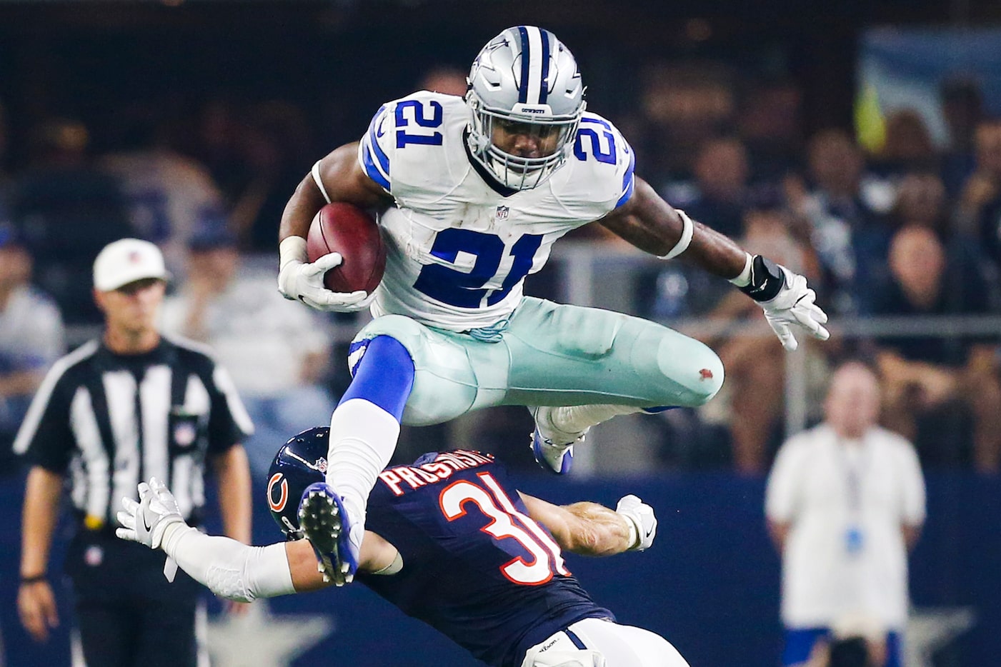 Dallas Cowboys running back Ezekiel Elliott (21) leaps over Chicago Bears strong safety...