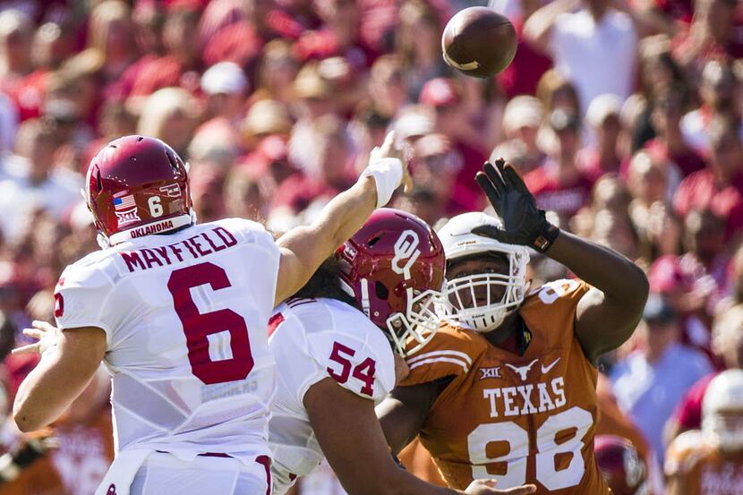 Oklahoma quarterback Baker Mayfield (6) passes under pressure from Texas defensive tackle...