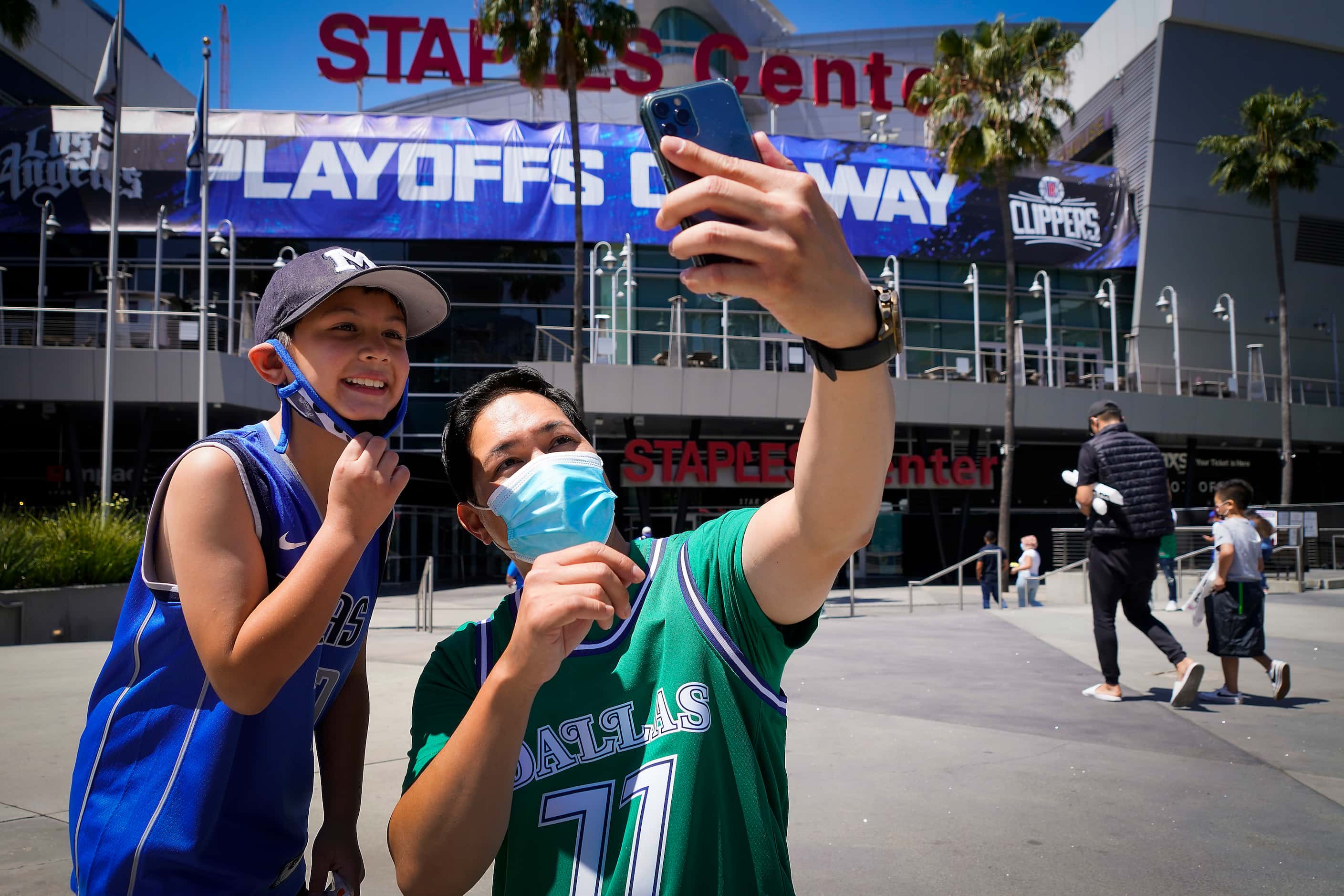Dallas Mavericks fan Michael Chen and his son Jack, 8, take a selfie outside the arena...