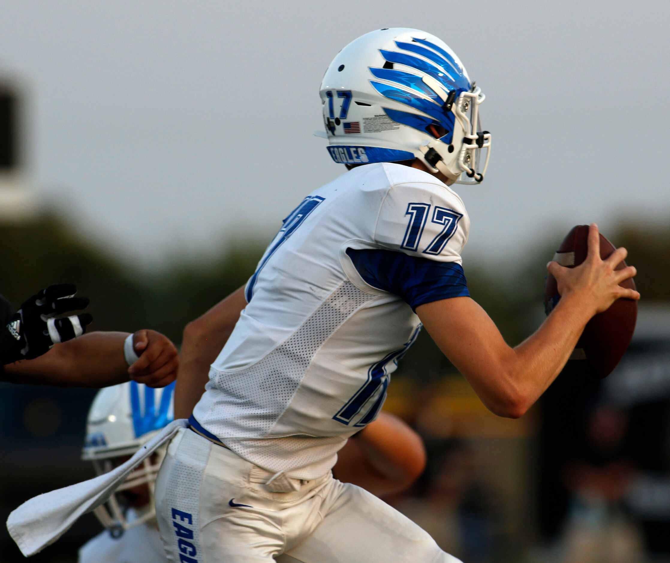Lindale quarterback Sam Peterson (17) scrambles out of the grasp of a Kaufman defender as he...