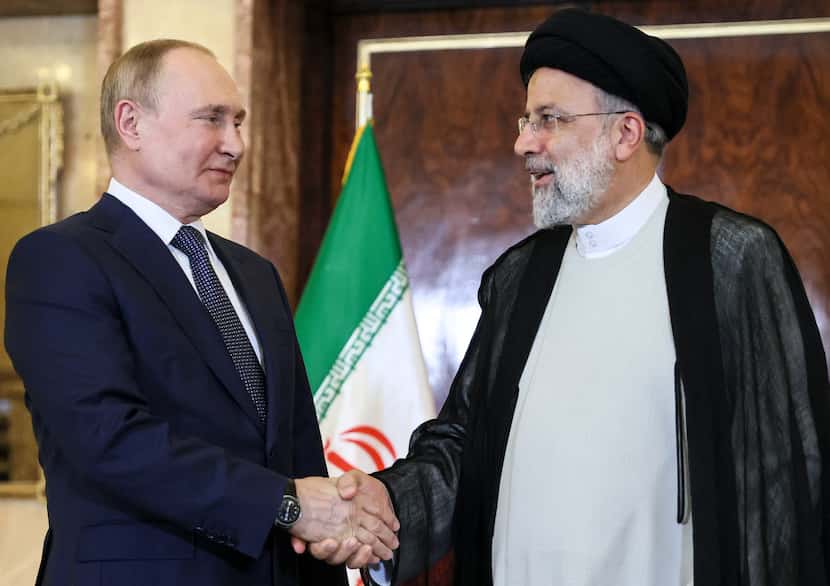 Iranian President Ebrahim Raisi shakes hands with Russian President Vladimir Putin prior to...