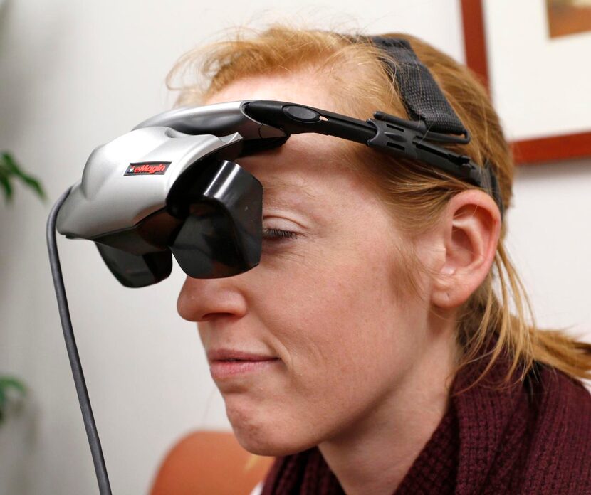 
Research assistant Katie Bridges demonstrates virtual reality goggles used for...