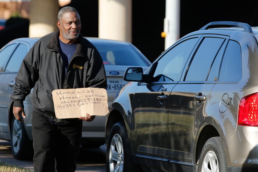 Louis Harris, 57, panhandles at the intersection I-35E and Market Center in Dallas on Dec....