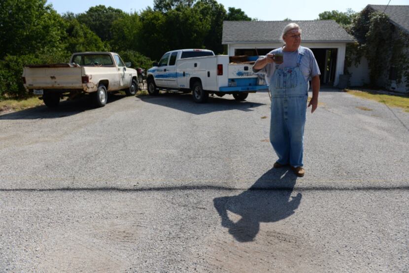 Joe Hardman stands at the line he spray painted to visualize how much of his driveway he...