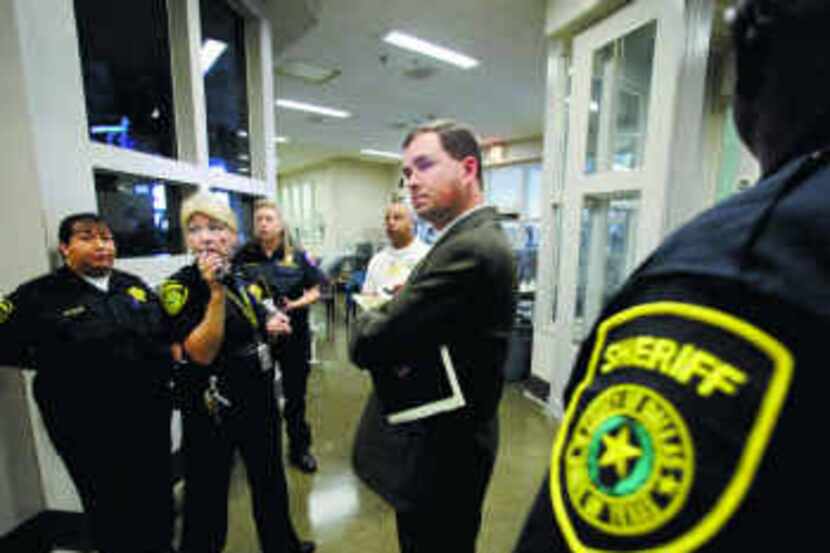 Brandon Wood (center), with the Texas Commission on Jail Standards, watched a safety test in...