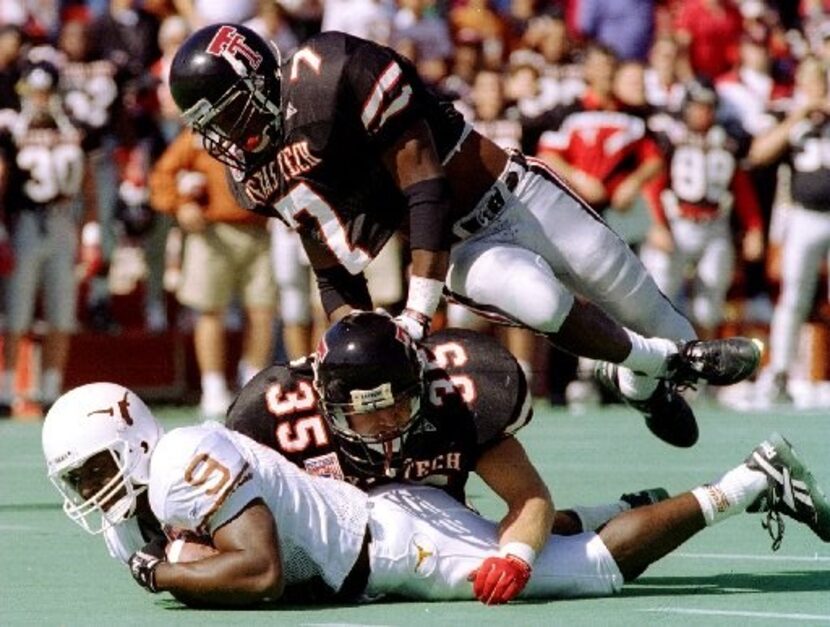 Texas Tech defenders Robert Johnson(7) and Zach Thomas(35)  bring down Texas's  Erick...