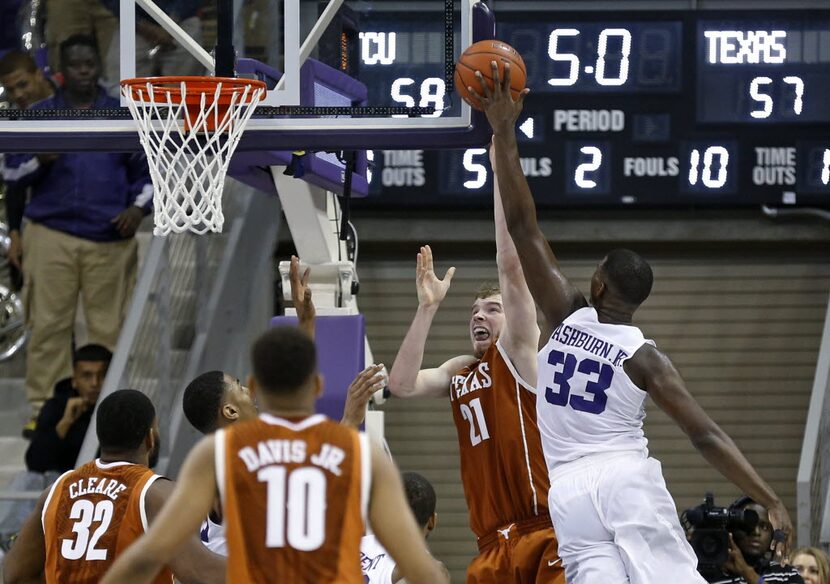 TCU forward Chris Washburn (33) blocks the shot of Texas forward Connor Lammert (21) with...