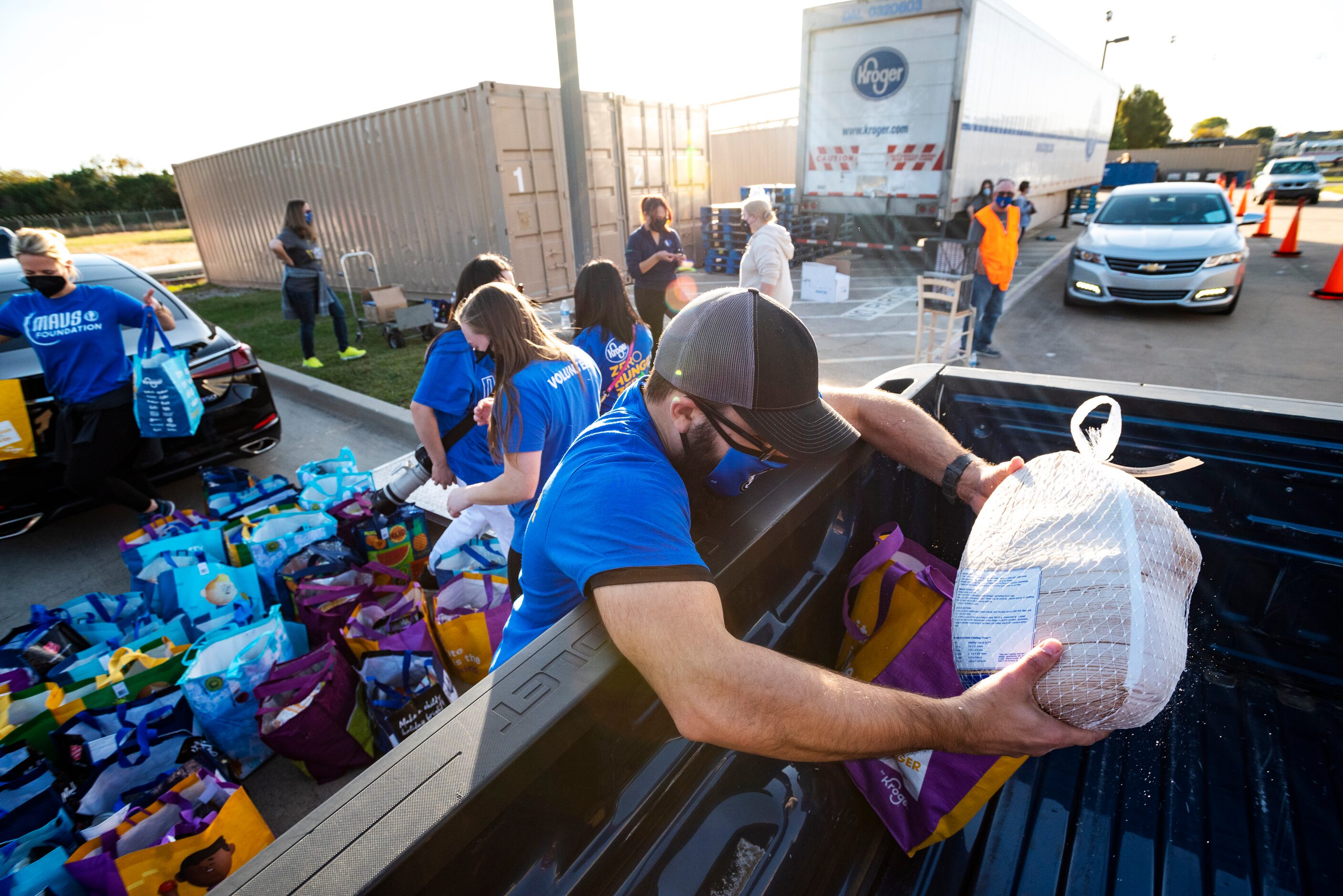 Kroger Human Resources employee Hiram Aponte loads a frozen turkey into the back of a...