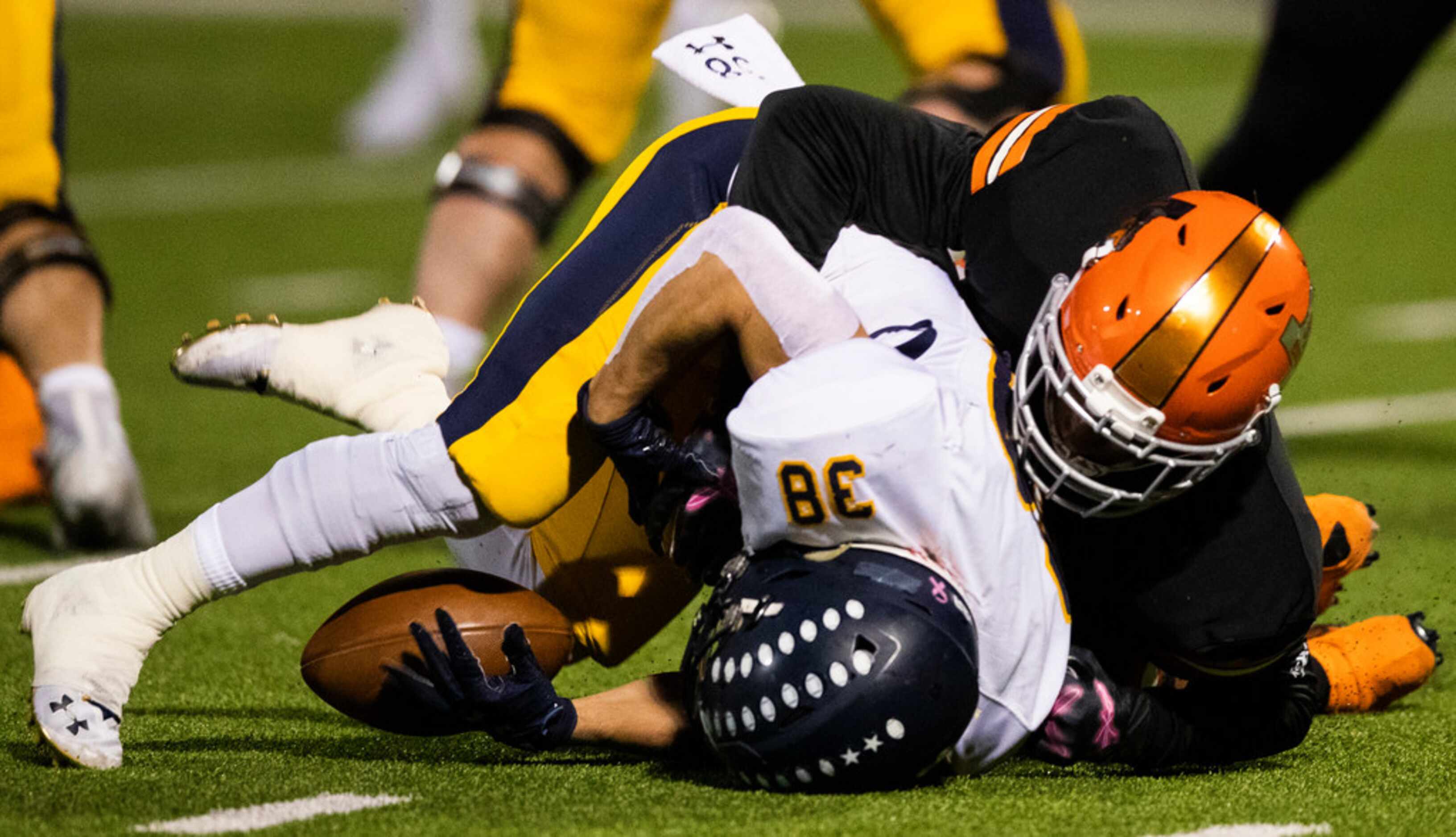 Highland Park running back Hunter Heath (38) fumbles the ball while being tackled by a...