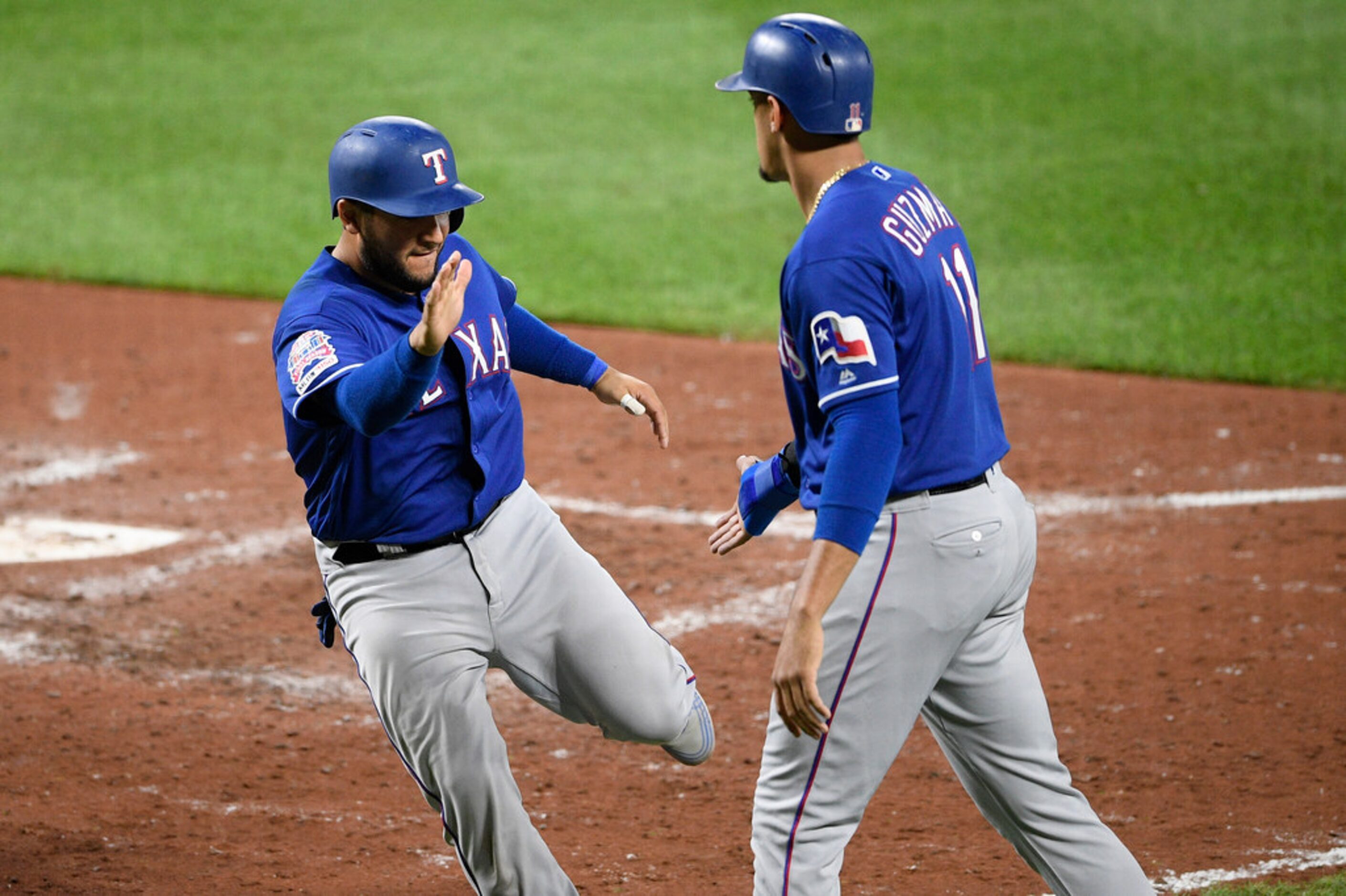 Texas Rangers' Jose Trevino, right, scores on a single by Elvis Andrus during the seventh...