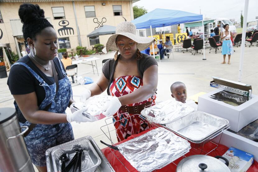 Shanay Wise, center, sets up her booth with her student Erica Refro, left, 15, at a...
