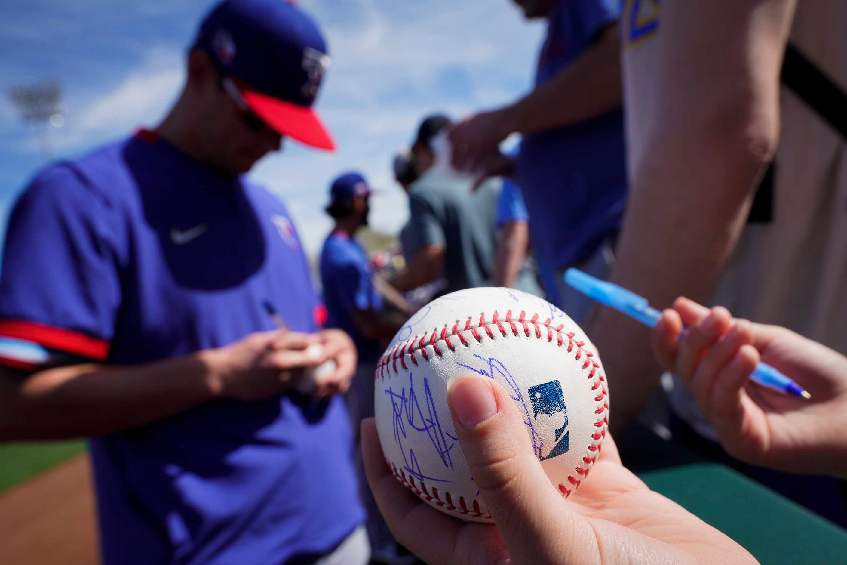 Texas Rangers infielder Nick Solak signs autographs before a spring game against the Kansas...