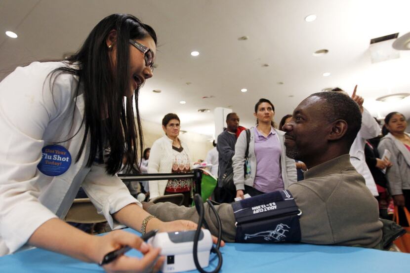 Helen Vo of Kroger measured Stephen Stewart's blood pressure during the Be Covered Texas...