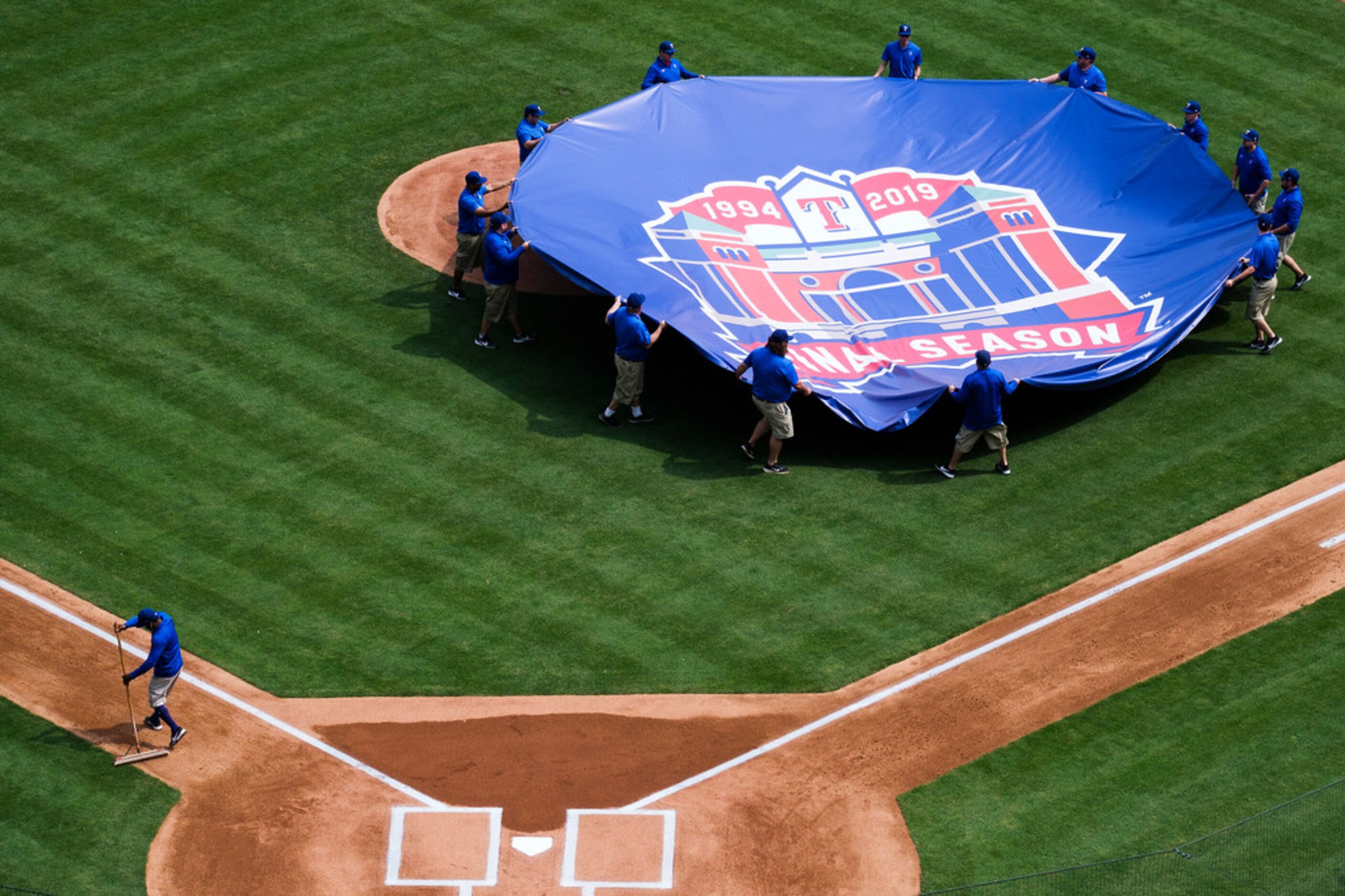 Groundskeepers preparer the field before the Texas Rangers opening day game against the...