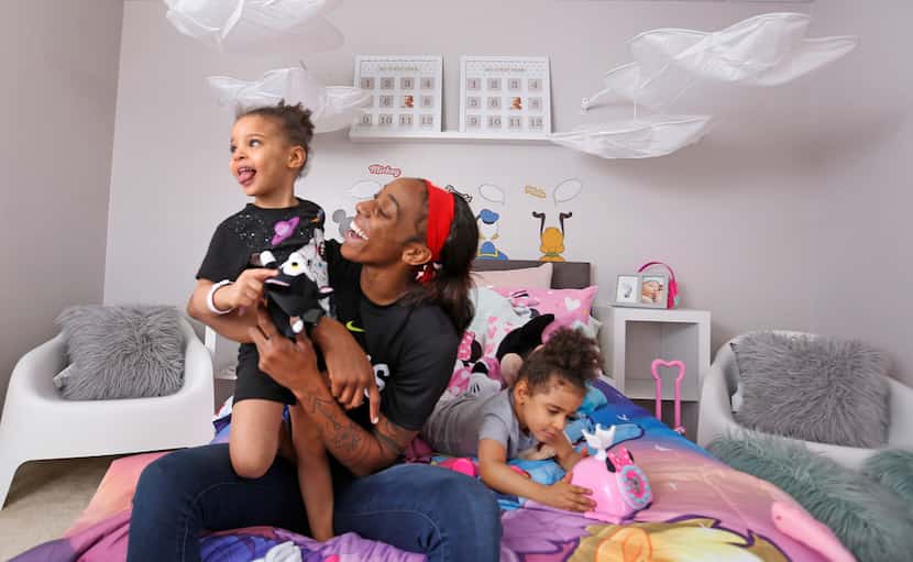Dallas Wings' player Glory Johnson plays with her twin daughters Ava, left, and Solei in...