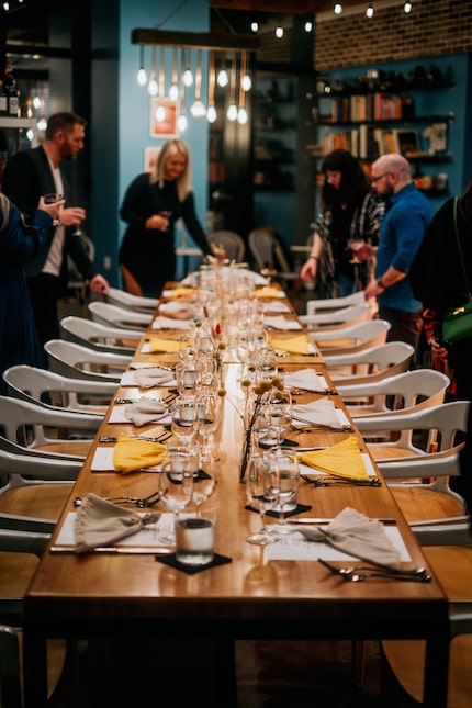 Diners take their seats at the 20-person communal table for Fond A.D., a monthly dinner...