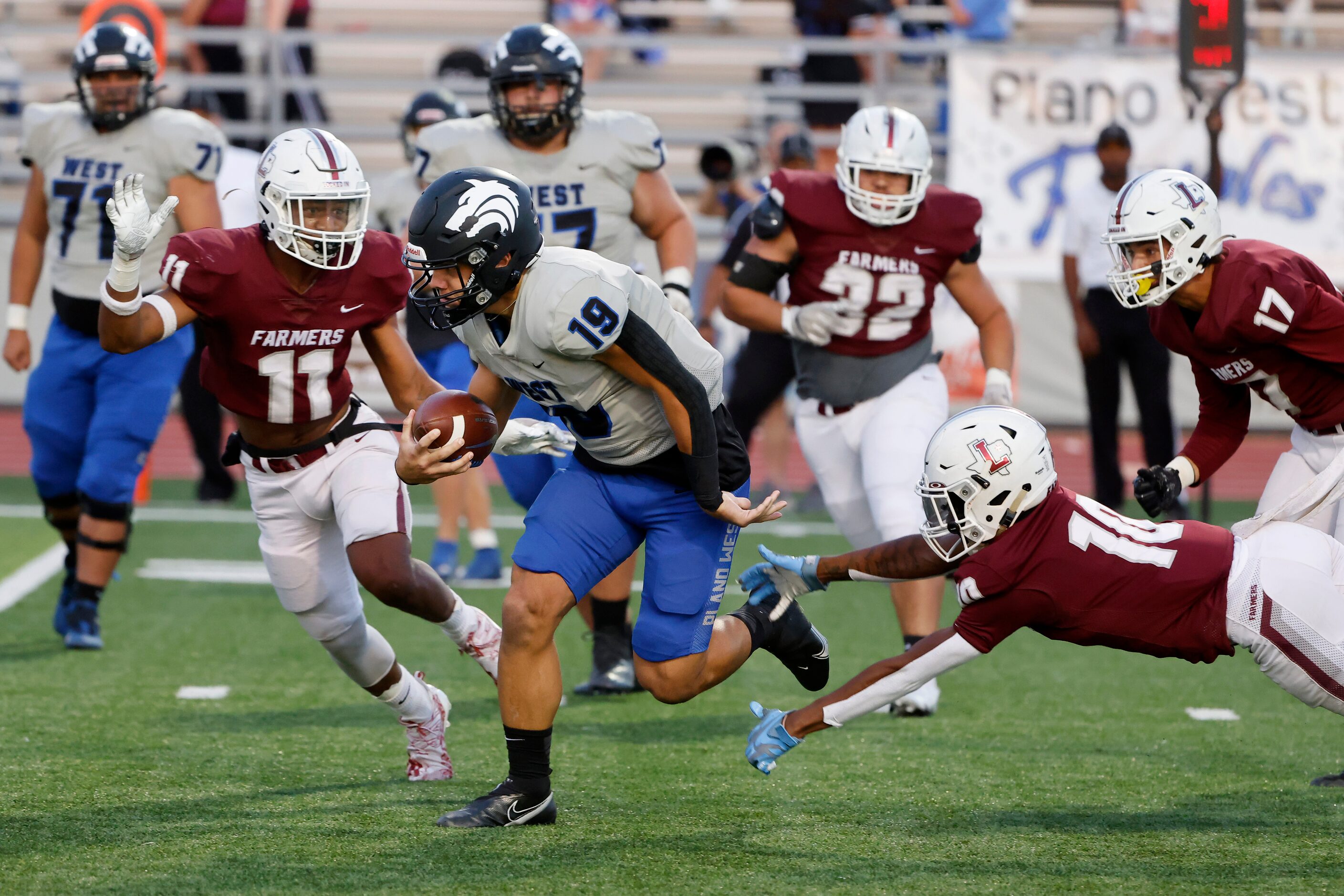 Plane West quarterback Vance Feuerbacher  (19) tries to run past Lewisville defenders Billy...