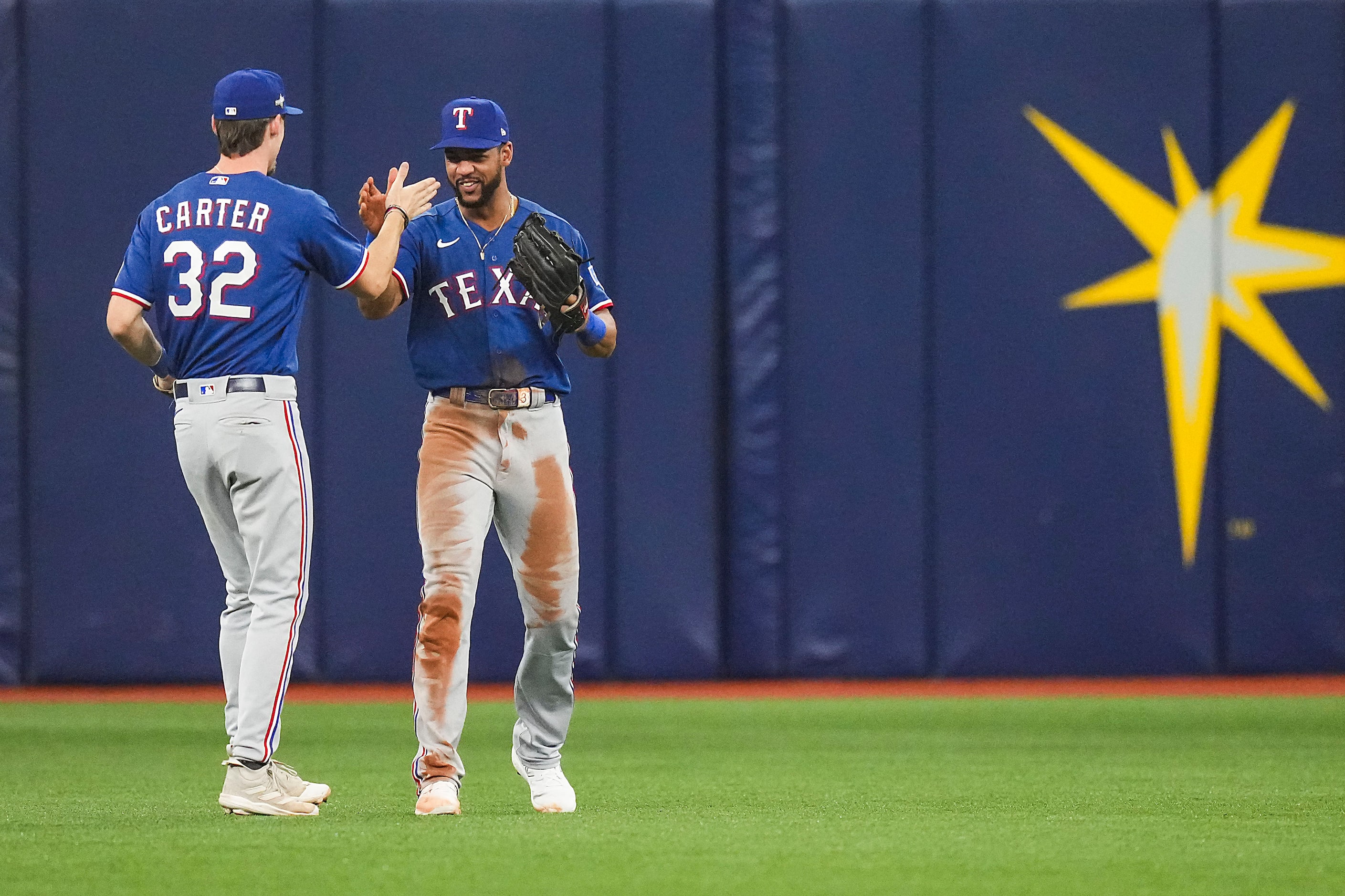 Texas Rangers left fielder Evan Carter (32) celebrates with center fielder Leody Taveras (3)...