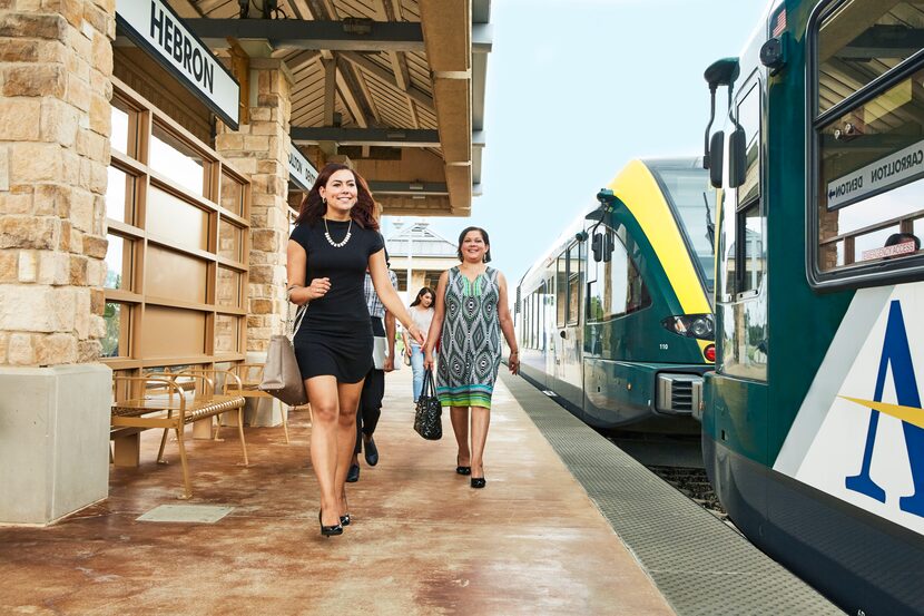 A group of women walking on the platform at a train station.