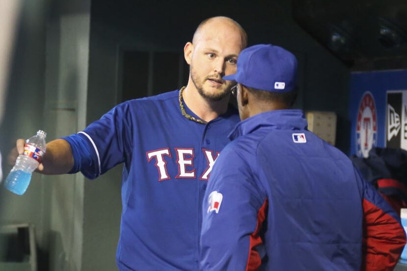 Texas starting pitcher Matt Harrison talks with manager Ron Washington in the dugout after...